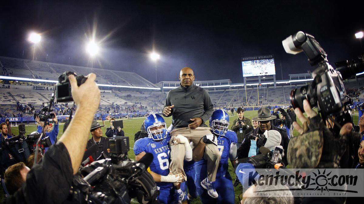 Kentucky football coach Joker Phillips was carried off the field by center Matt Smith, left, and guard Larry Warford in his final game after Kentucky defeated Samford 34-3 in the Wildcats' home finale. Philips had been fired two weeks earlier.  Photo by Mark Cornelison | Staff 