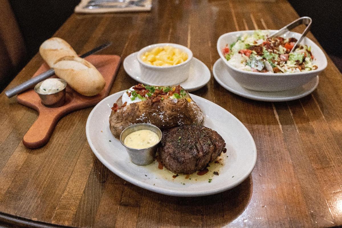 A filet steak and loaded baked potato, bottom center, Malone’s Lexingtonian salad, top right, macaroni and cheese, top center, and bread, top left, offered at Malone’s steakhouse. Bluegrass Hospitality Group is celebrating the 25th anniversary of the first Malone’s restaurant location at Lansdowne shopping center in Lexington with a a special menu and contests.