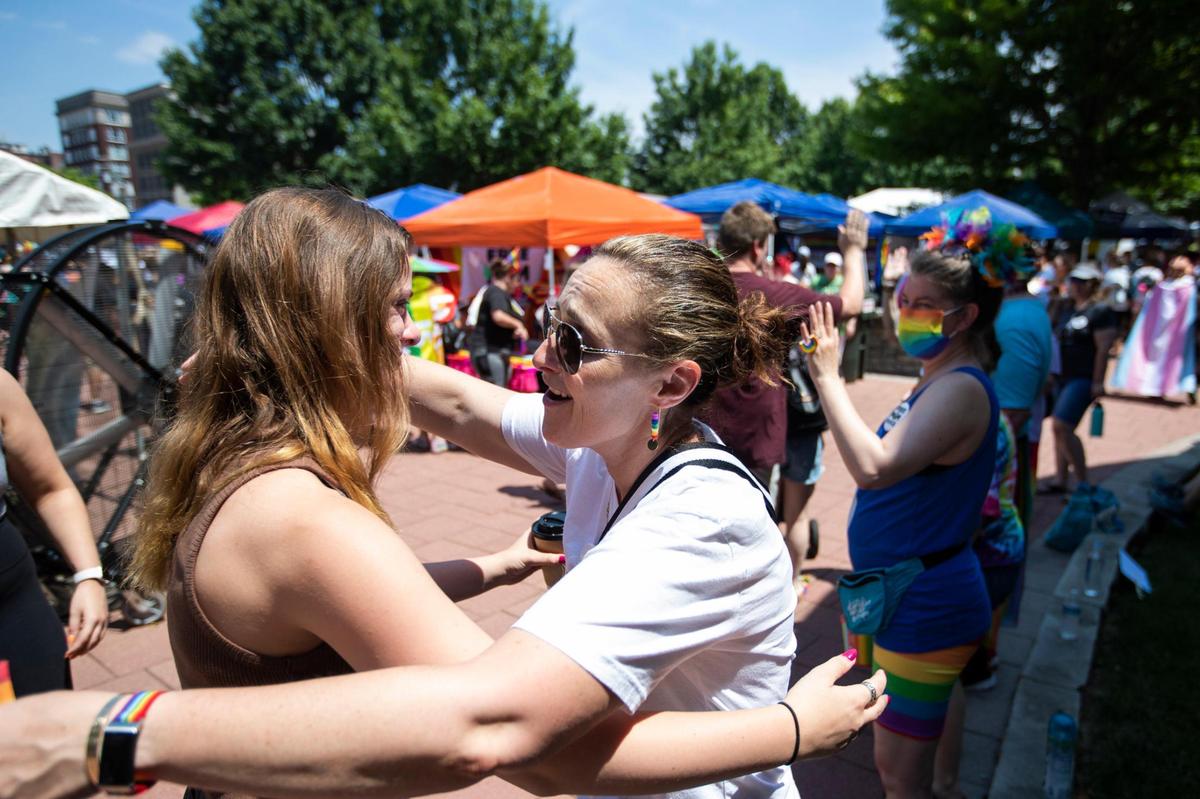 Bobbi Silver, of Georgetown, offers hugs and high-fives to attendees paying by during the annual Lexington Pride Festival in front of the Robert Stephens Courthouse in Lexington, Ky., Saturday, June 25, 2022.