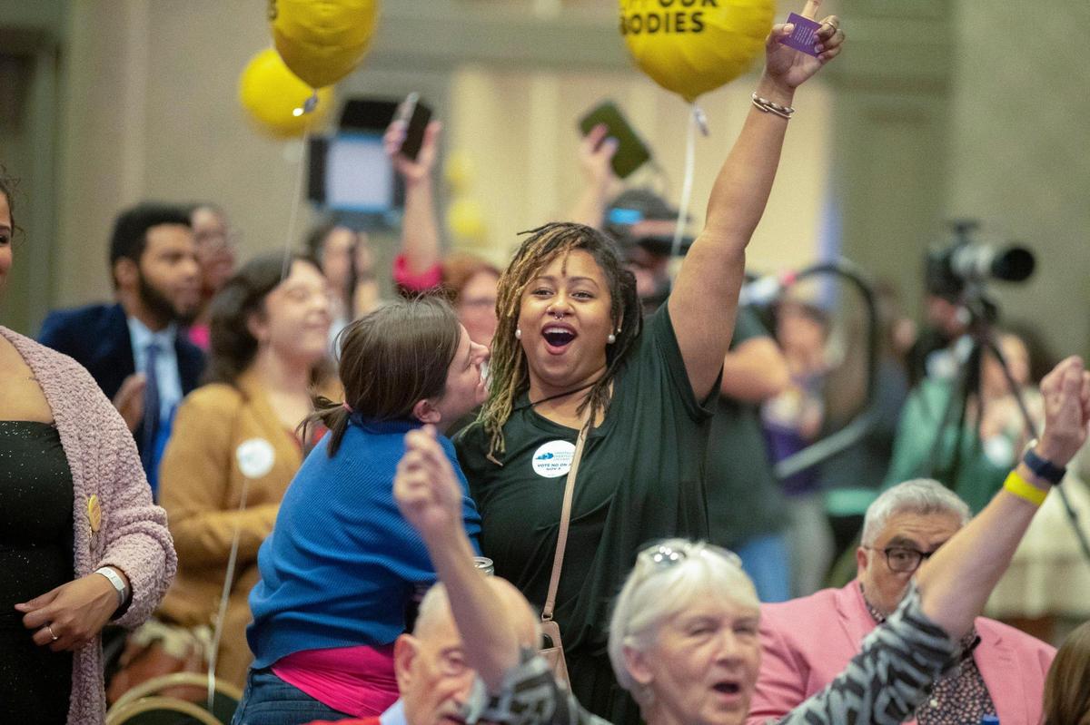 Amira Bryant, with arm extended, celebrates after it’s announced on television that Kentucky Amendment 2 is likely to be defeated during a Protect Kentucky Access’ election watch party the Galt House in Louisville, Ky., on Tuesday, Nov. 8, 2022.