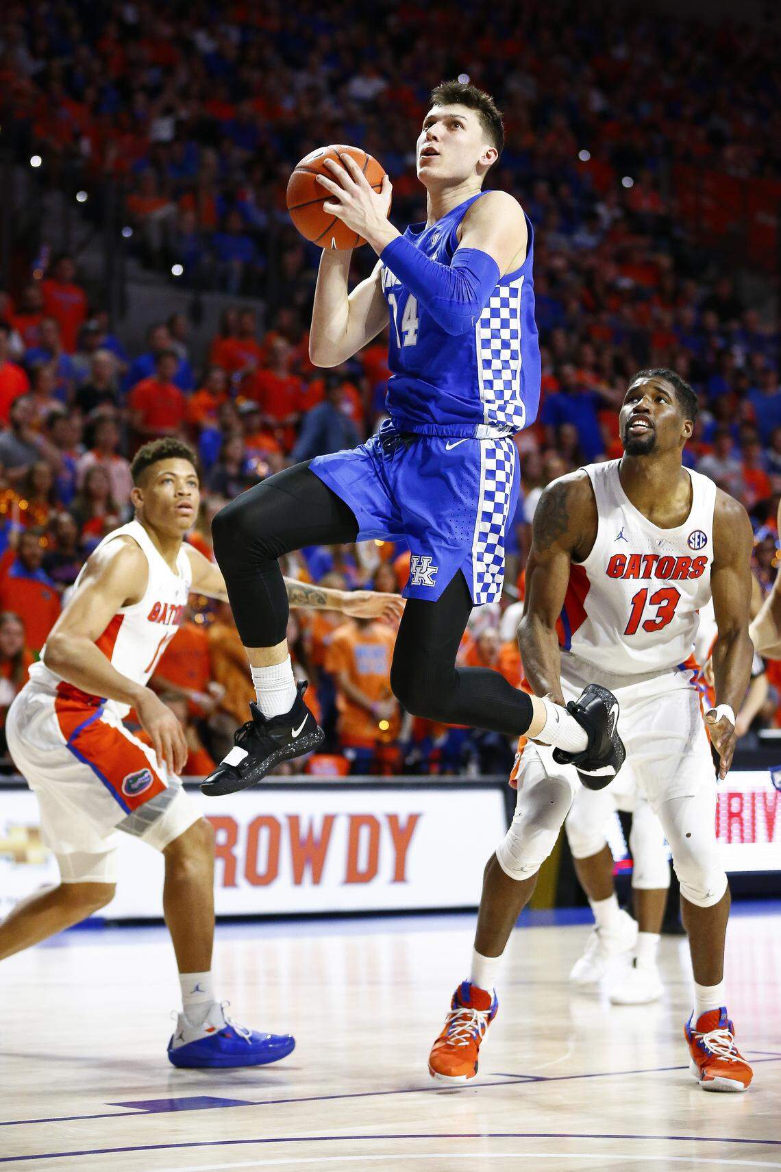 Kentucky Wildcats guard Tyler Herro (14) went to the hoop past Florida Gators forward Keyontae Johnson (11) and Florida Gators center Kevarrius Hayes (13) during their game at the Exactech Arena at Stephen C. OÕConnell Center in Gainesville Saturday, Feb. 2, 2019. Kentucky beat Florida 65-54.