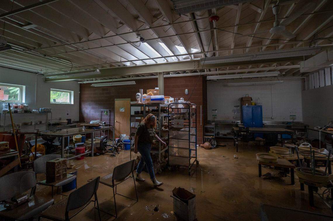 Renee Anderson, Appalachian Artisan Center artistic director, walks through the building Thursday, July 28, 2022, after it was damaged by flood waters that swept through Hindman, Ky., early in the morning. (Ryan C. Hermens/Lexington Herald-Leader via AP)