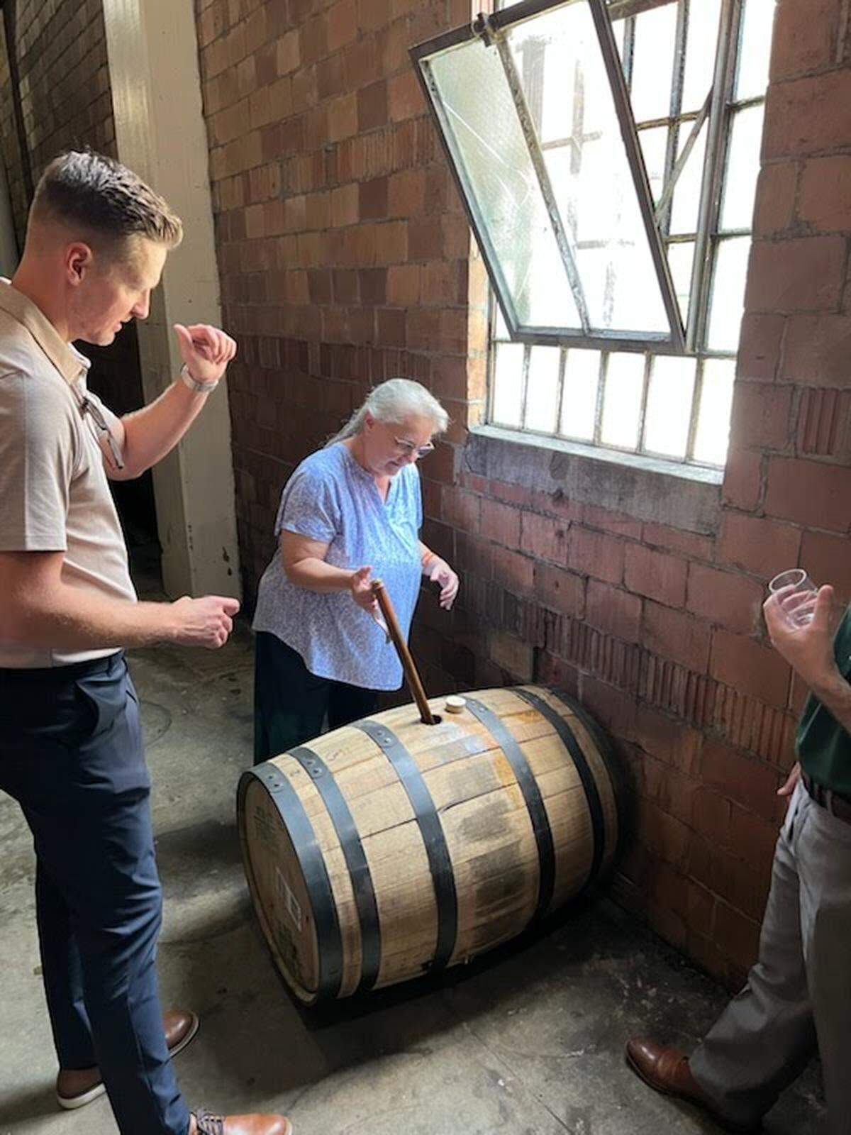 Herald-Leader reporter Janet Patton “thieving” bourbon from a barrel of Weller at Buffalo Trace with Andrew Duncan, Sazerac global brand director, left, and brand manager Charley Costa, right.