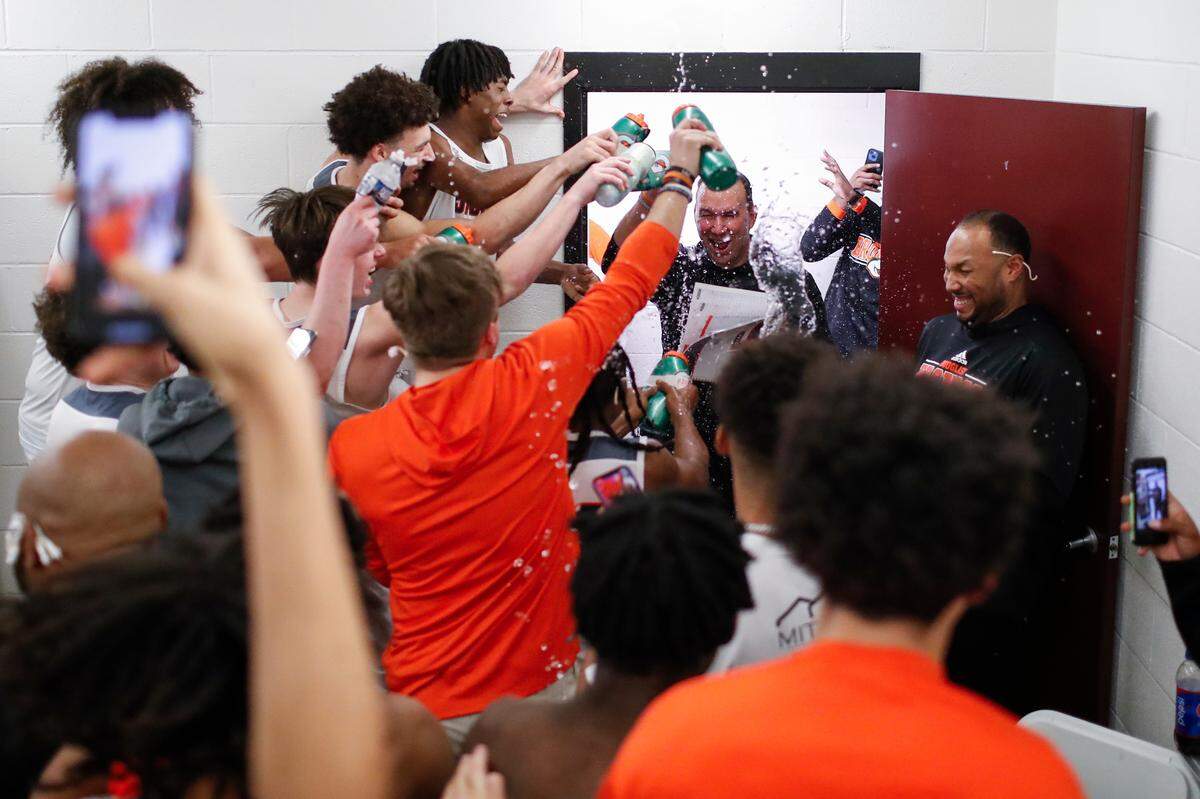 Frederick Douglass head coach Wes Scarberry is sprayed with water while entering the locker room after winning the 11th Region Tournament Championship game at Alumni Coliseum in Richmond, Ky., Monday, March 6, 2023. Douglass advanced to the KHSAA Sweet Sixteen with a three-pointer with 13.3 seconds left in the game, giving the Broncos’ a 43-41 win.