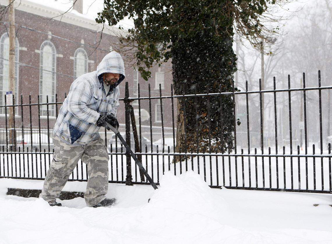 Jose Mares clears a sidewalk on Broadway near Second St. as heavy snow falls during a winter storm in Lexington, Ky., Monday, February 16, 2015. Photo by Matt Goins