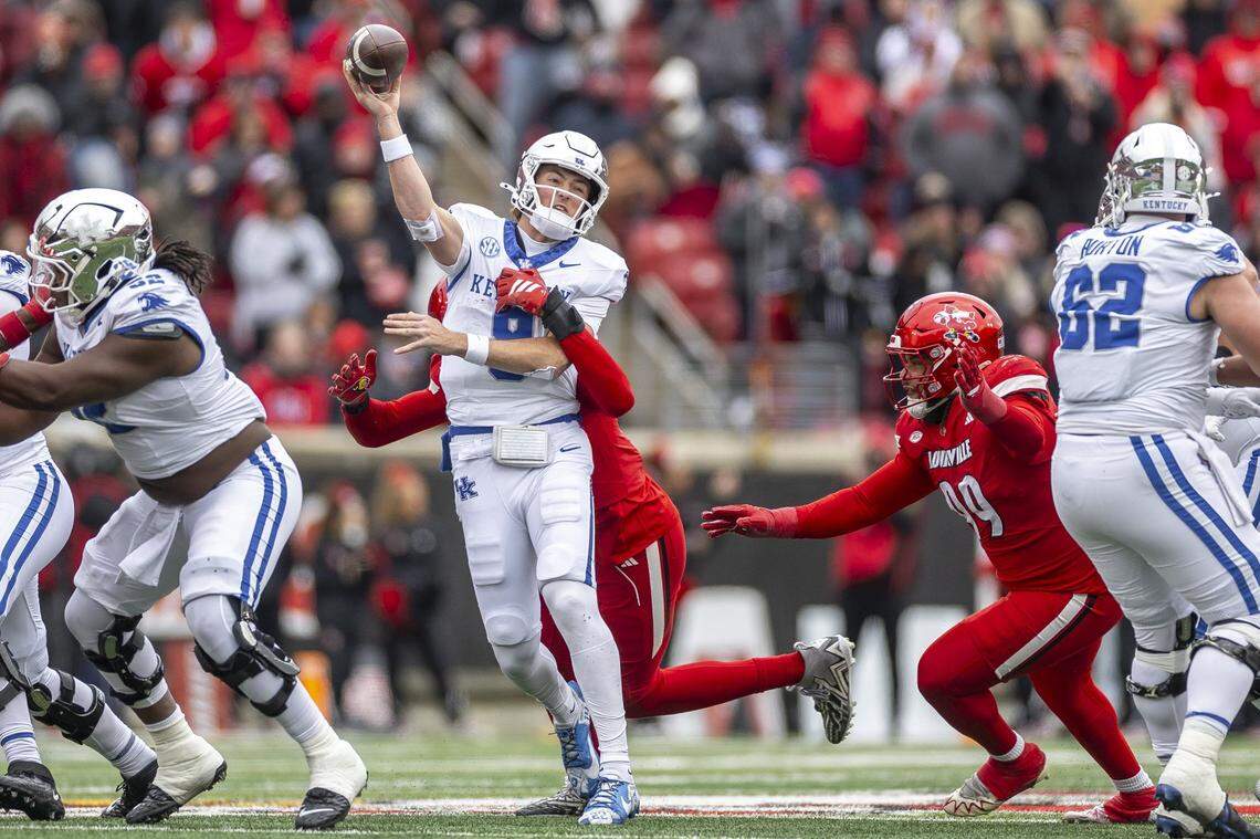 Kentucky quarterback Cutter Boley (8) looks to pass the ball as Louisville defensive lineman AJ Green (17) wraps him up during the Governor’s Cup game Saturday.