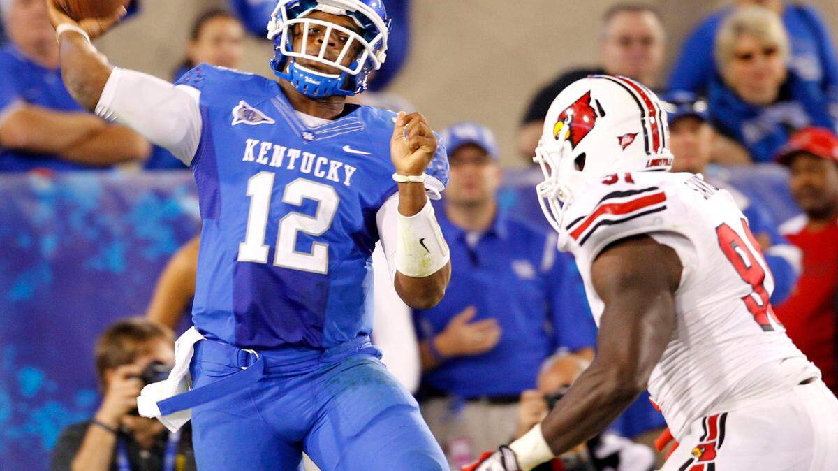 Kentucky quarterback Morgan Newton hurled a pass off his back foot as he hurried to avoid Cardinals defensive end William Savoy in the end zone. The completion resulted in a first down.