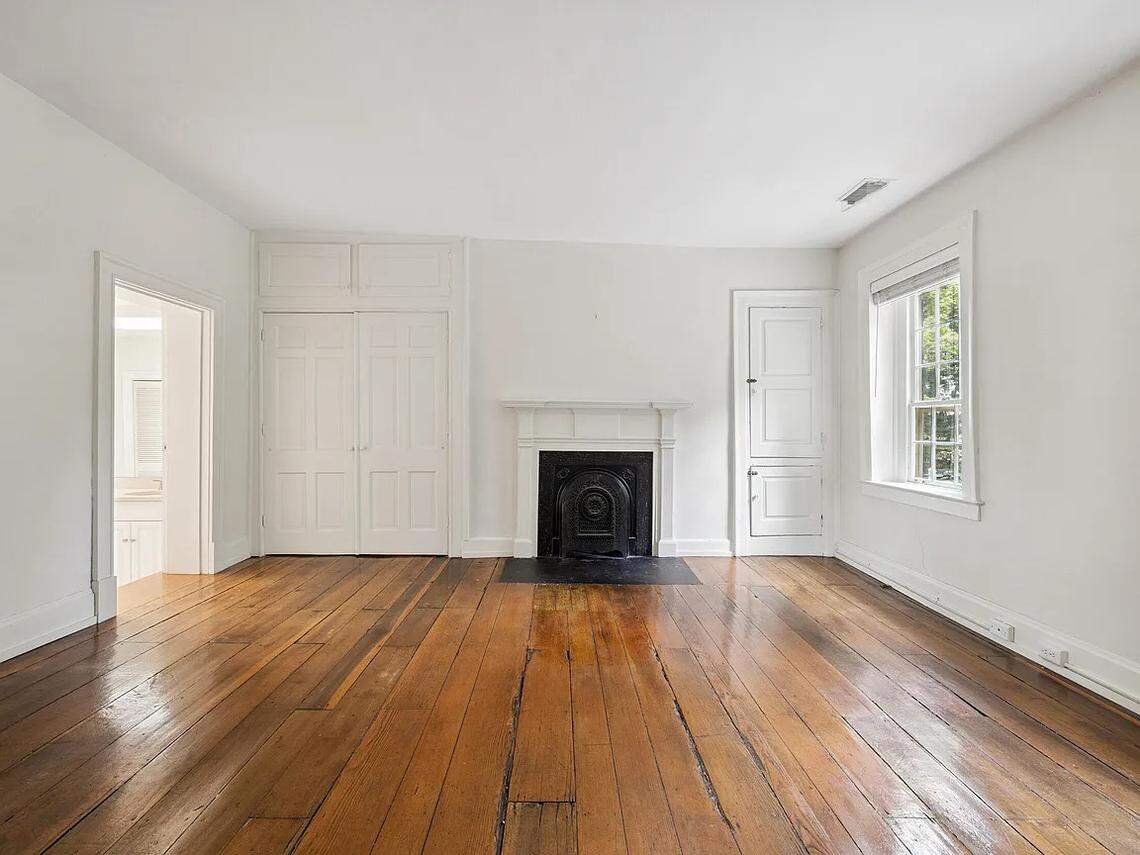 A view of a suite in 220 Market Street. There's an adjoining bathroom with two sinks, and in the bedroom itself, a fireplace. 