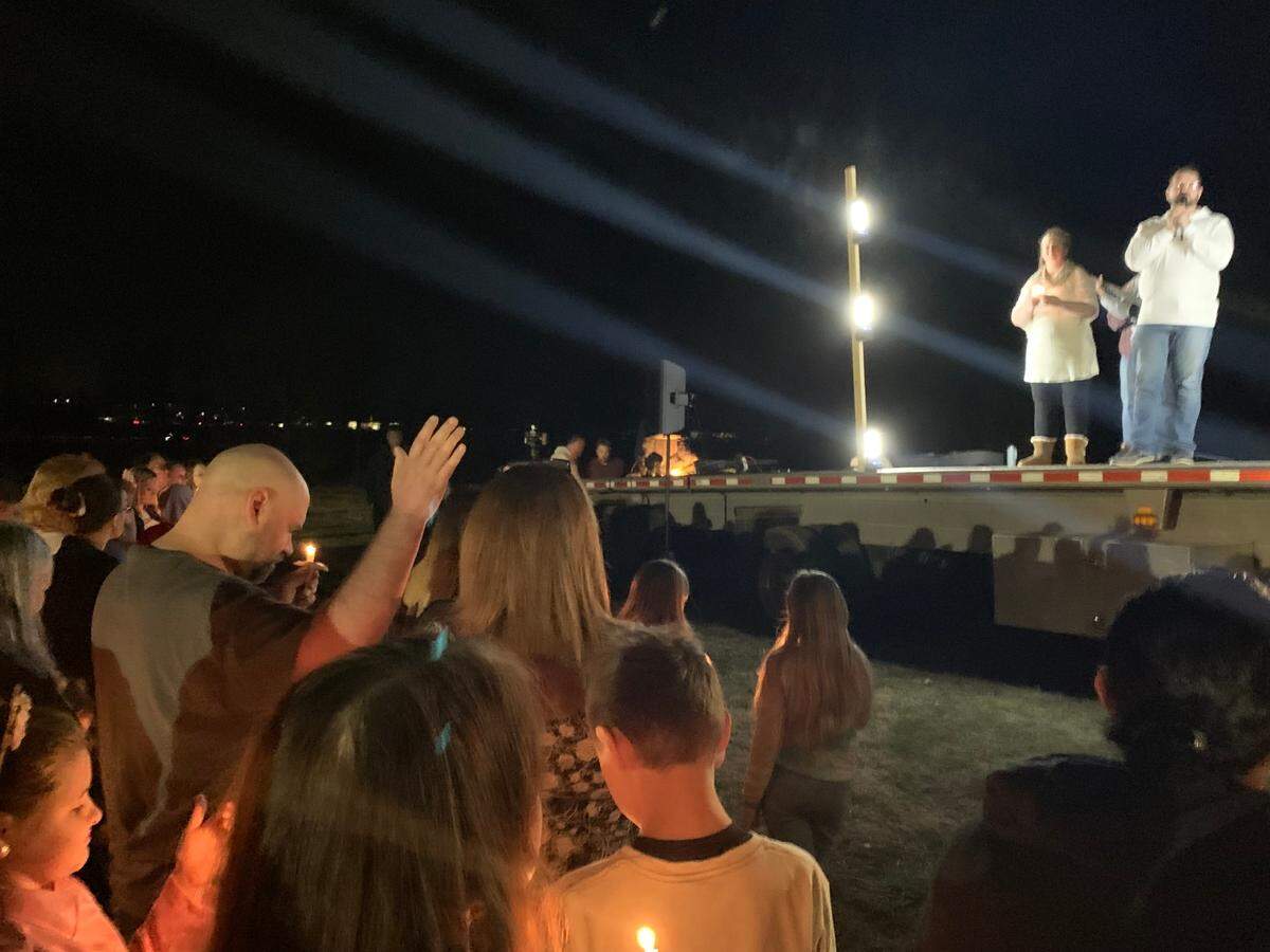 Attendees bowed their heads at a candelight vigil held in honor of those who died in a storm that hit Mayfield as His House Ministries Pastor Stephen Boyken said a prayer.