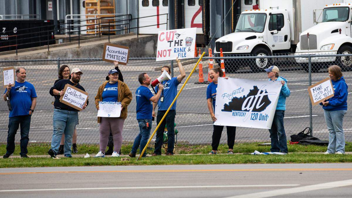 Councilmember Emma Curtis of Lexington's 4th District stands in solidarity with teachers and staff during a demonstration held in front of the Fayette County Public Schools Warehouse on Russell Cave in Lexington, Ky. Secretary Treasurer of Kentucky 120 United-AFT, James Woodhead (holding the megaphone), led the protest, speaking out against financial cuts being made by Fayette County Public School officials, that resulted in layoffs, due to longstanding financial accounting errors that created an inaccurate picture of the district budget.