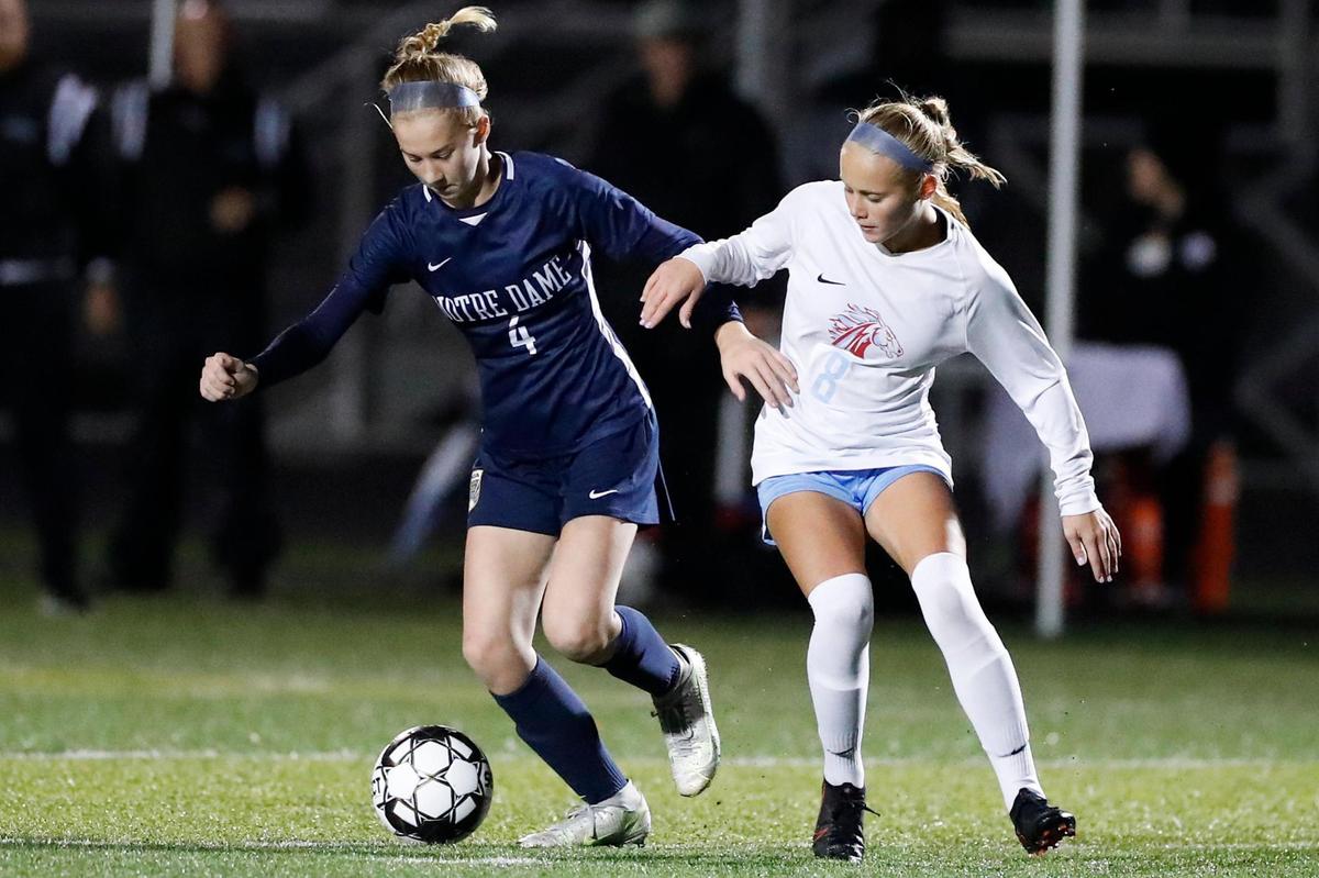 Notre Dame’s Megan McGraw (4) and West Jessamine’s Karlie Galus (8) battle for the ball during Thursday night’s state semifinal match at Frederick Douglass.