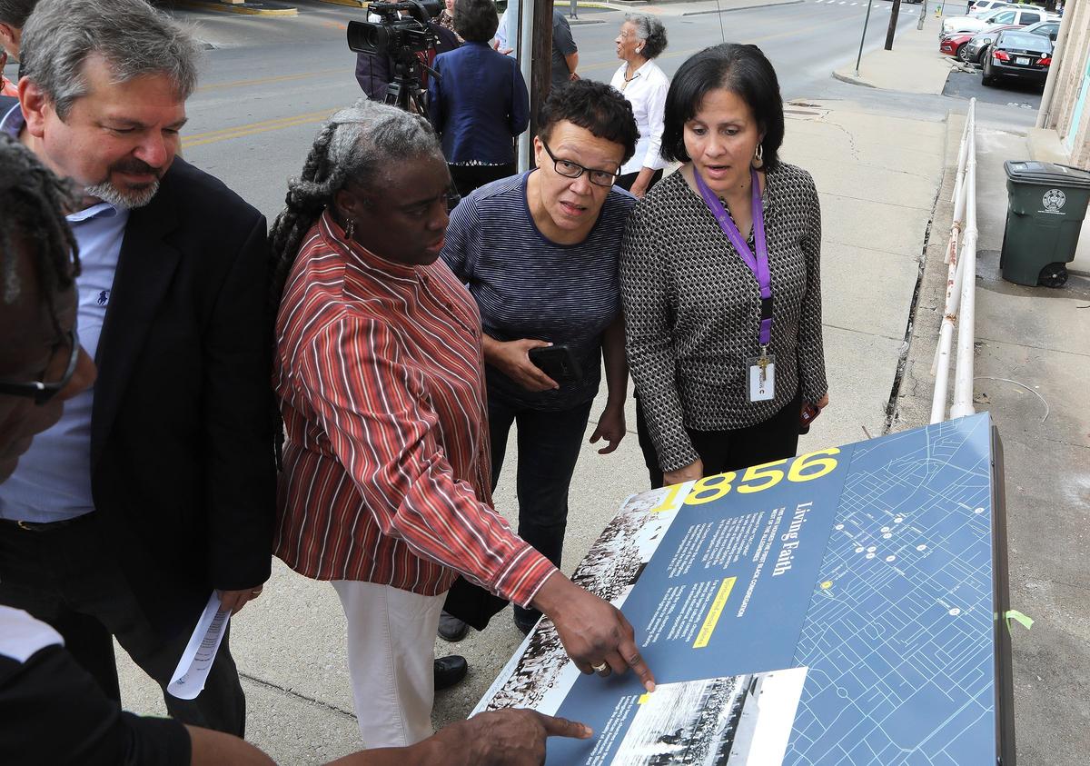 Reinette Jones, Phaon Patton and Delphine Ridgeway discussed the marker with Thomas Tolliver, left, after it was unveiled Thursday at a press conference to announce the creation of the African-American Heritage Trail on DeWeese Street. Photo by Matt Goins