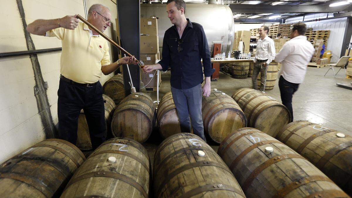 Four Roses Master Distiller Jim Rutledge poured a glass of one of the 10 Four Roses mash bills for Luke Ford to sample as he and others in a group from Seven Grand, a whiskey bar in Los Angeles and San Diego, selected two barrels of Four Roses straight bourbon for their bar, during a private barrel tasting and selection event at the Four Roses Warehouse and Bottling facility, in Cox's Creek, Ky., Wednesday, September 18, 2013. The bourbon will be bottled and labeled with their personalized label. Photo by Charles Bertram | Staff