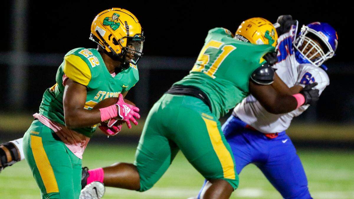 Bryan Station’s Jeremiah Mundy-Lloyd (22) runs as teammate Keion Watson (51) blocks during their team’s game against Madison Central on, Friday, Oct. 21, 2022.
