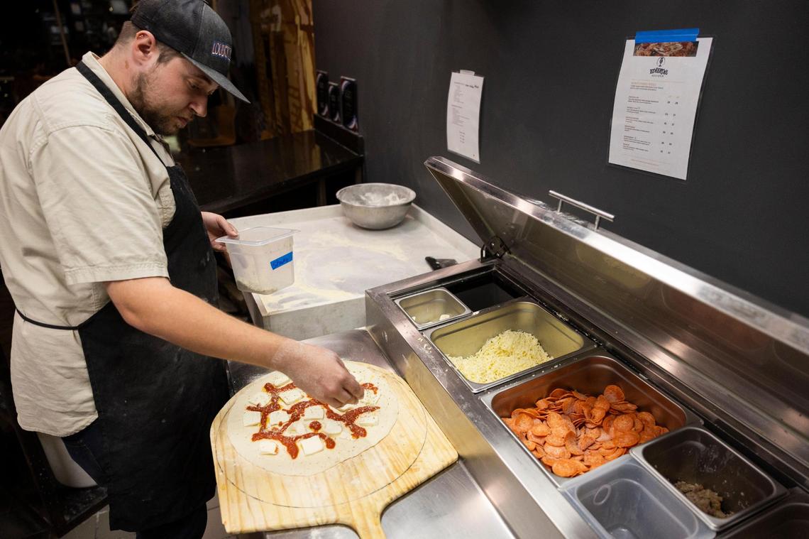Ethereal Slice House employees prepare old world style pizza a brick style oven.