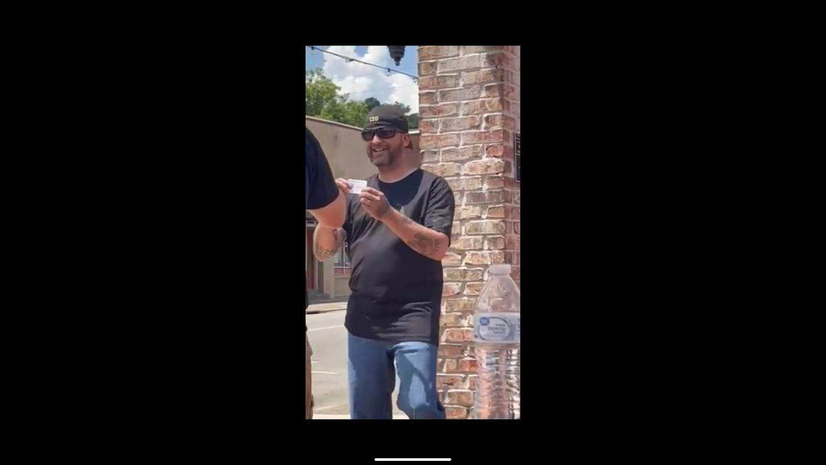 An unidentified man shows what protesters called a Klan membership card.