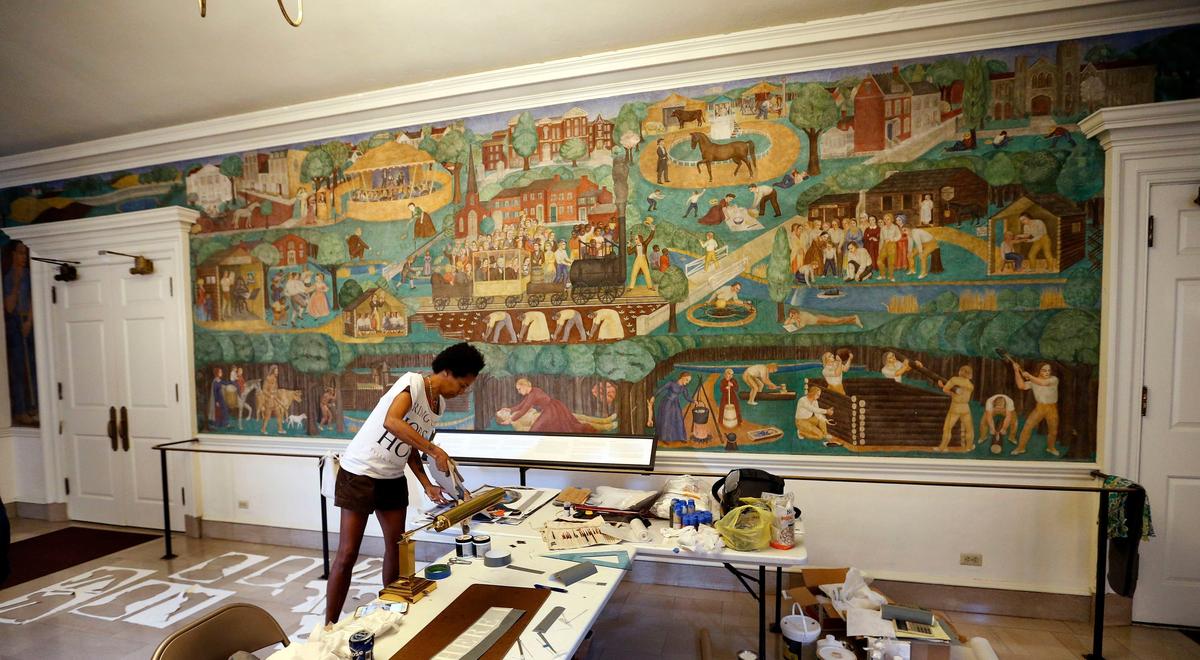 Artist Karyn Olivier is creating contextual art around UK’s controversial 1930s mural, on wall in background, in Memorial Hall. Her new work will be titled “Witness” and is being created around the dome near the entrance to the building.
