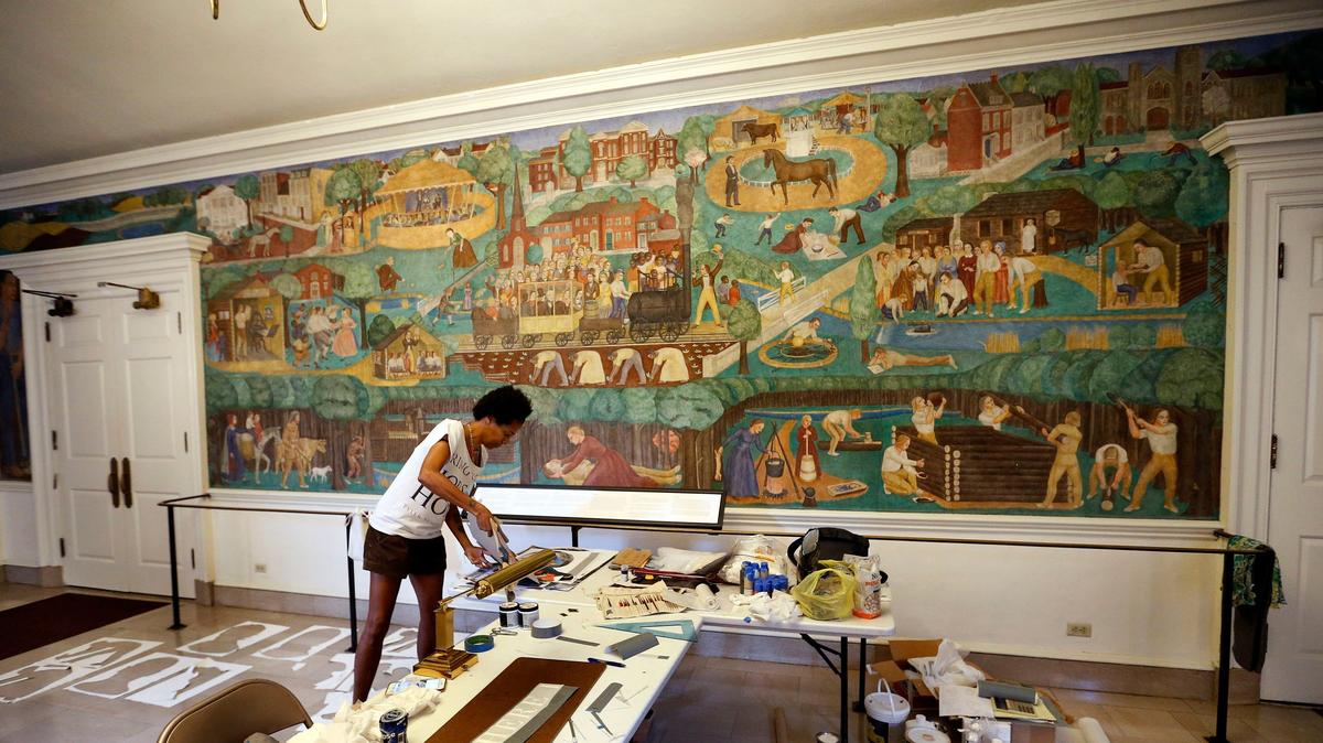 Artist Karyn Olivier is creating contextual art around UK’s controversial 1930s mural, on wall in background, in Memorial Hall. Her new work will be titled “Witness” and is being created around the dome near the entrance to the building.