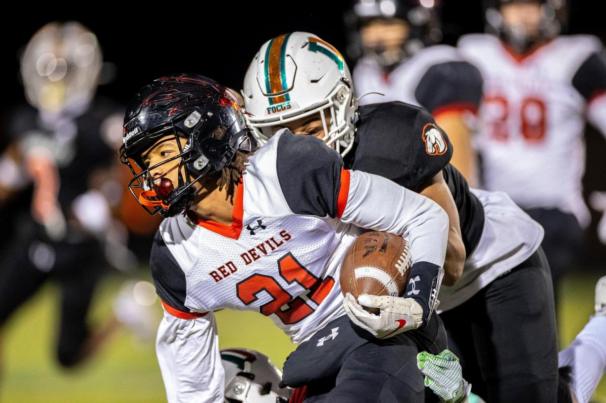 Owensboro’s Kenyatta Carbon (21) tries to elude a Frederick Douglass defender Friday night. The Broncos limited the state’s highest-scoring offense (48.5 points per game) to seven points.