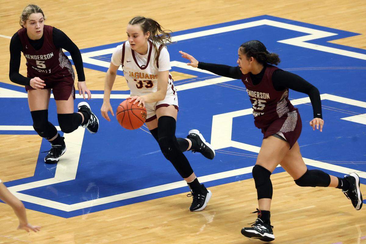 Henderson County’s Adalyn Gish (5) and Atylia Green (25) chase Cooper’s Logan Luebbers Palmer (33) during Friday night’s game. Palmore finished with seven points.
