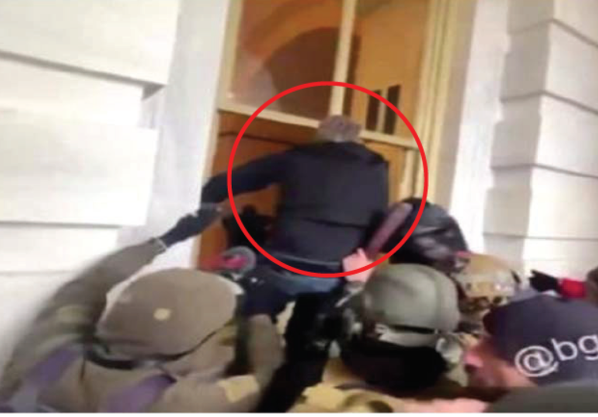 According to the FBI, this photo shows Michael Sparks of Kentucky climbing through a broken window at the U.S. Capitol on Jan. 6, 2021. Authorities said Sparks was the first person to illegally enter the building during the disturbance.