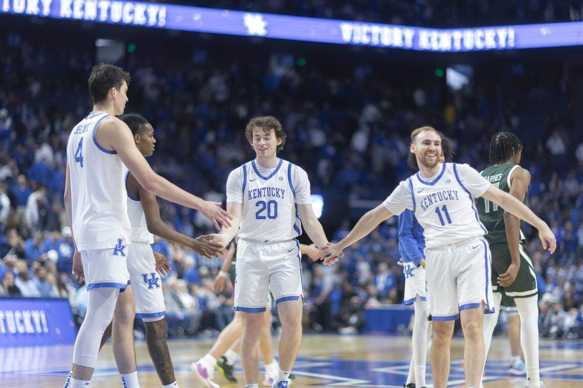Kentucky basketball forward Zach Tow (20) receives high-fives from his teammates, including guard Walker Horn (11), during a game against Loyola (Maryland) at Rupp Arena on Nov. 21. 