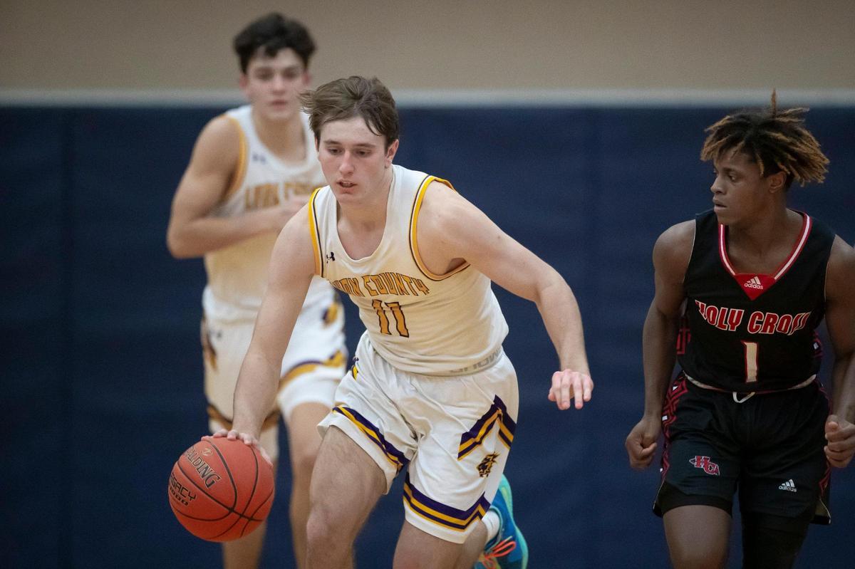 Lyon County’s Travis Perry (11) brings the ball up the court with Covington Holy Cross’s Javier Ward (1) trailing during the Lyons’ 95-79 opening-round win. Perry finished with 27 points.