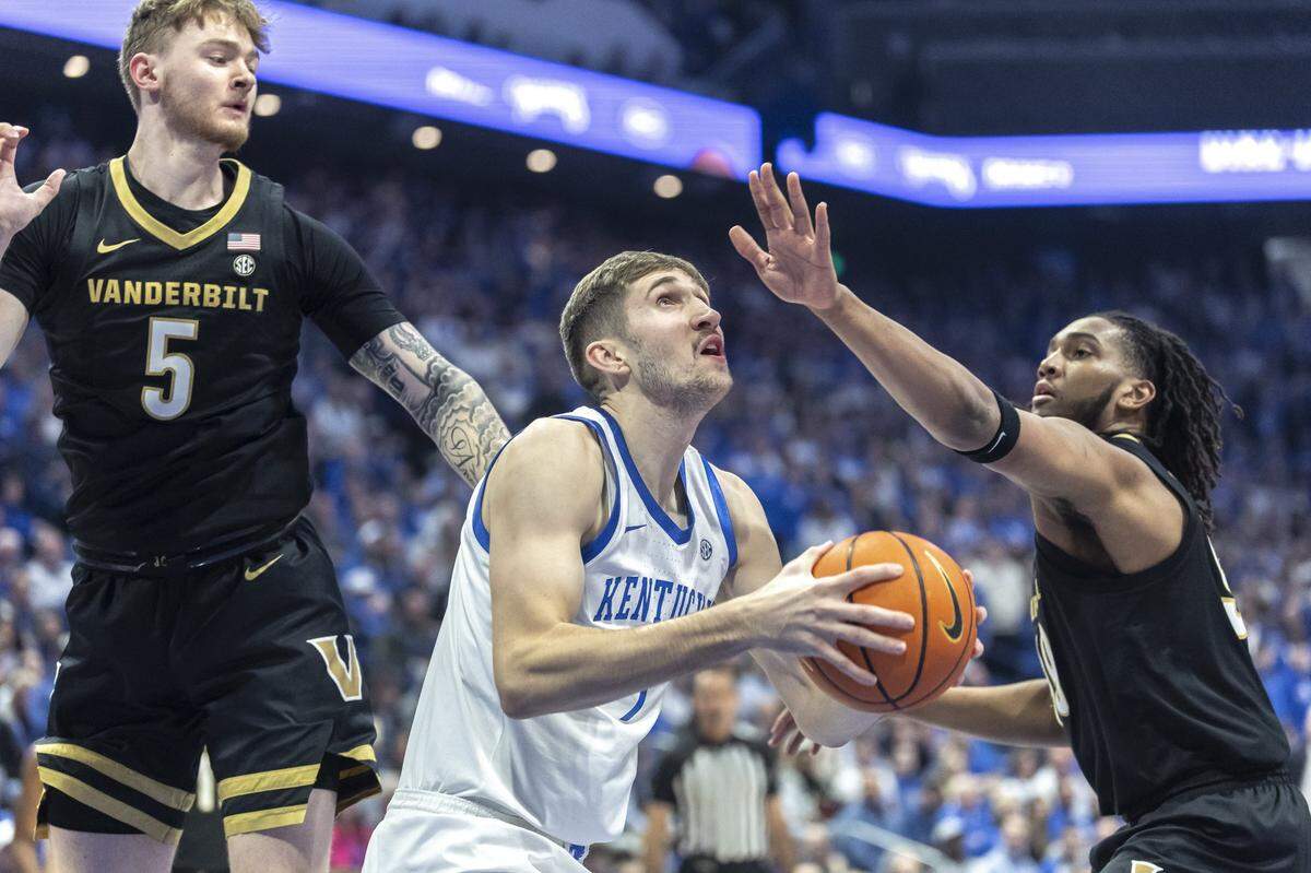 Kentucky’s Andrew Carr (7) looks to shoot against Vanderbilt’s Tyler Nickel (5) and Devin McGlockton (99) during Wednesday’s game at Rupp Arena.