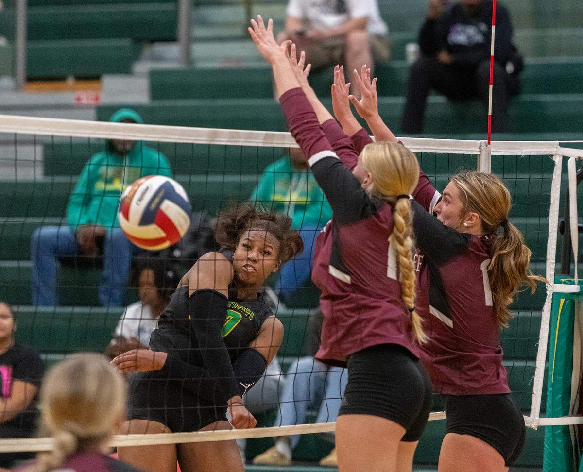 Bryan Station senior Cameron Owens (30) gets a kill against around Tates Creek’s block attempt in the fourth set of the Defenders’ 3-1 win at Bryan Station High School on Tuesday.