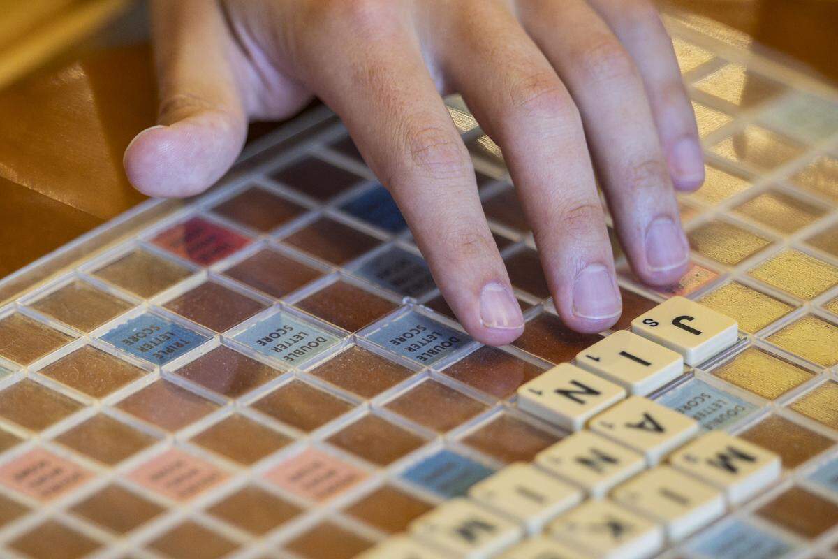 Mack Meller plays a short word during a Scrabble club meeting on Sunday, July 27, 2025, at Sedona Taphouse in Lexington, Ky. Meller said there were seven different spellings for this same word.