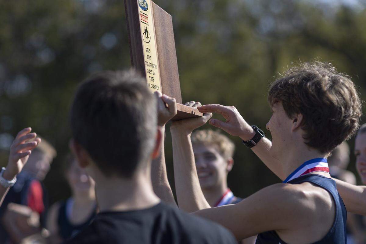 Members of the Lafayette boys team celebrate after receiving their team championship trophy during the 2025 KHSAA Class 3A State Cross Country Meet at the Kentucky Horse Park in Lexington, Ky., on Saturday, Nov. 1, 2025.