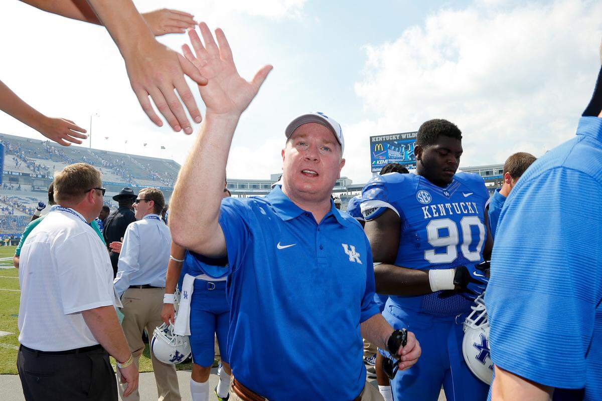 Kentucky Coach Mark Stoops was high-fived as he left the field after the Cats defeated Miami (Ohio) 41-7 in 2013 for Stoops’ first win as UK head coach.
