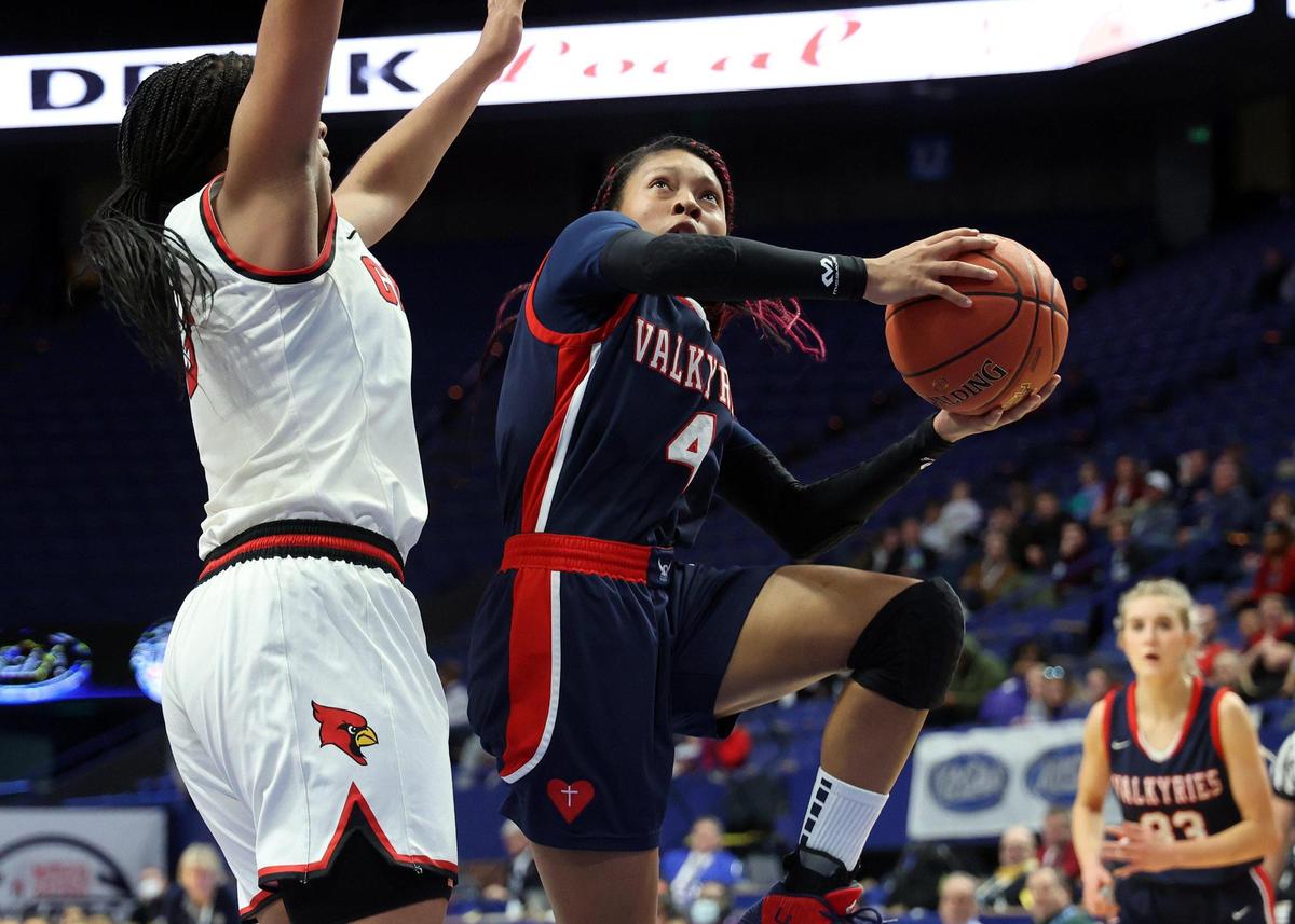 Sacred Heart’s Triniti Ralston (4) shoots while pressured by Clark County’s Ciara Byars (3) on Friday night. Ralston led the Valkyries with 22 points.