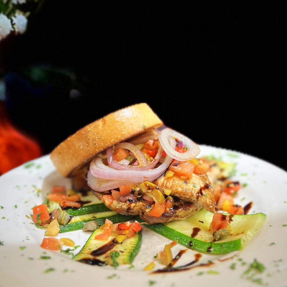 Tuscan Chicken, two grilled chicken breasts with grilled zucchini and red onion with house bruschetta and balsamic drizzle from Josie’s.