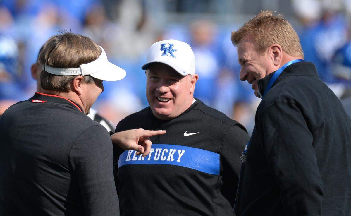 Georgia Coach Kirby Smart, left, chatted with UK head coach Mark Stoops, and his brother, Mike, prior to the the Bulldogs beating the Wildcats 34-17 on Nov. 3, 2018, in the game that decided the SEC East Division champion.