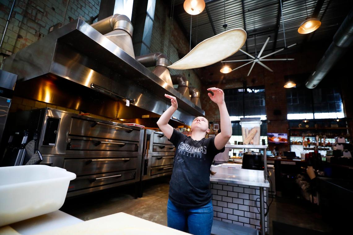 Jessica Jones tosses pizza dough Saturday for a takeout order at Goodfellas Pizzeria in the Distillery District