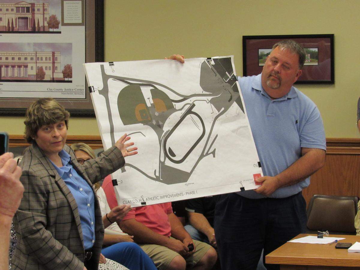 Sharon Allen, left, attorney for the Clay County Board of Education, and Superintendent William Sexton, right, at a July 8, 2021 meeting show a map of planned construction near a cemetery on land the school system owns.