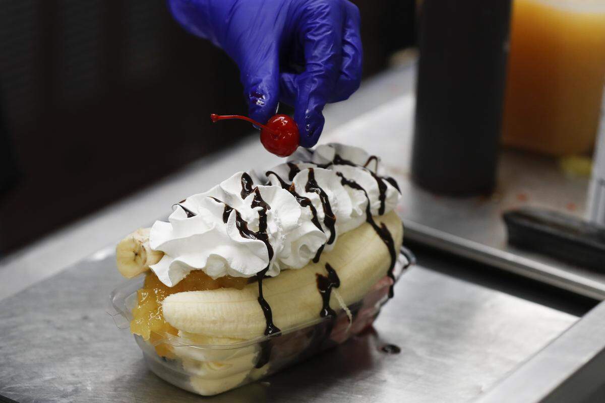 Lauren Hatfield places a cheery on a banana split May 2 at the Parkette Drive-In restaurant.
