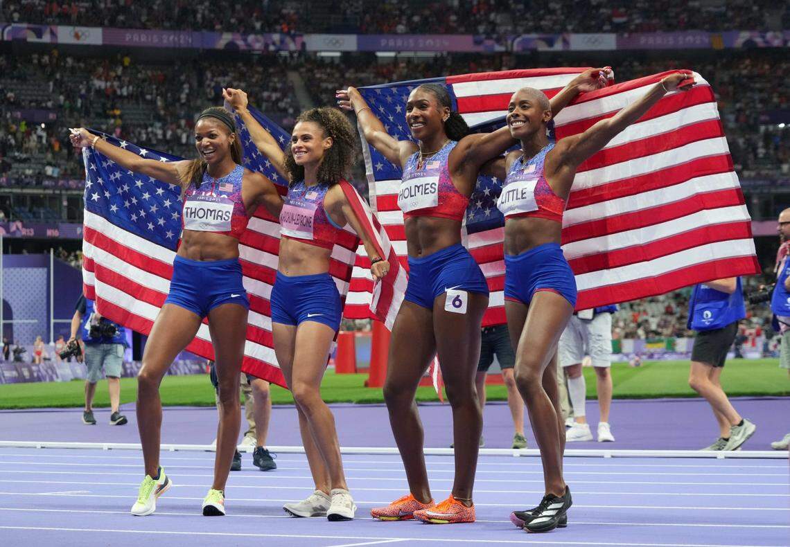 Former Kentucky Wildcats track stars Alexis Holmes, third from left, and Sydney McLaughlin-Levrone, second from left, celebrated with Team USA teammates, Shamier Little, far right, and Gabrielle Thomas, far left, after winning the Olympics gold medal in the women’s 4x400 meters relay in Paris.