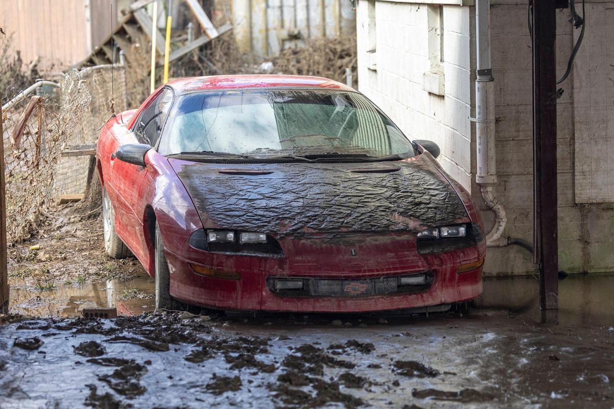 Mud remains on the hood of a car after flood waters receded from a house on Mullins School Street in Pike County, Ky., Heavy rainfall lead to flooding throughout Kentucky over the weekend.