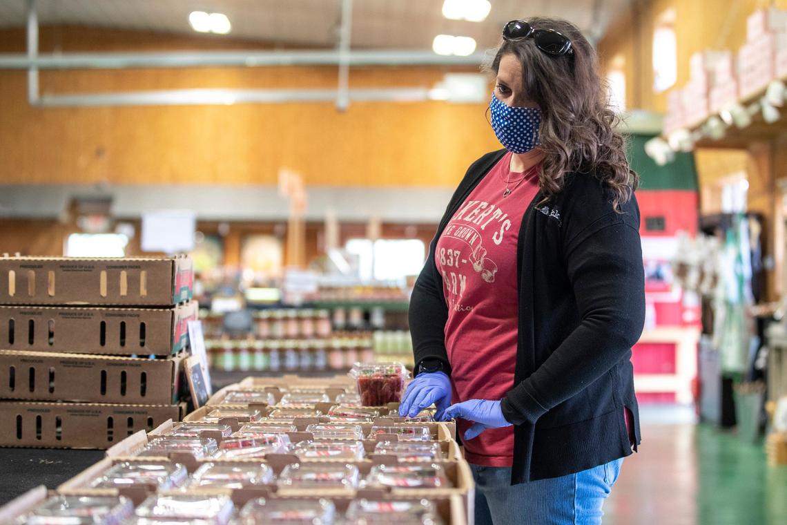 Megan Fields, Eckert’s Farm general manager, organizes containers full of strawberries at the farm’s country store in Versailles. Despite not being able to offer customers the option to pick fruit, the farm has plenty of fruit to purchase.