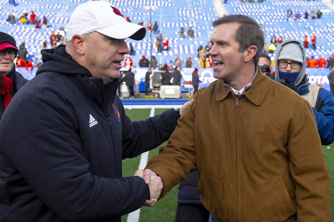 Louisville coach Jeff Brohm, left, shook hands with Kentucky Gov. Andy Beshear following Cardinals’ 41-14 victory over the Kentucky Wildcats at Kroger Field in the 2024 regular-season finale for both teams.