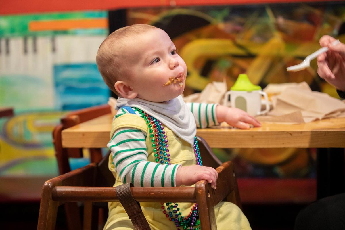 One-year-old Wyler Johnson, wearing Mardi Gras beads in honor of Fat Tuesday, tries out the Southwest etouffee with crawfish, with a little help from his mother, Ashley Johnson, of Georgetown, at Bourbon n’ Toulouse in Lexington, Ky., Tuesday, Feb. 25, 2020. Ashley said she visited the restaurant specially for Fat Tuesday.