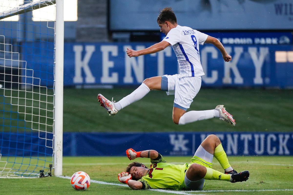 Kentucky midfielder Marcel Meinzer jumps over Louisville goalkeeper Osmar Chavero while trying to score with the ball in the first half during a game at Wendell & Vickie Bell Soccer Complex in Lexington, Ky., Tuesday, September 6, 2022. The UK team won both the Sun Belt Conference regular season and tournament championships in its first season in the league, and finished the regular season undefeated for the first time in school history. But for the third straight season, UK was eliminated in the NCAA Tournament Sweet 16.