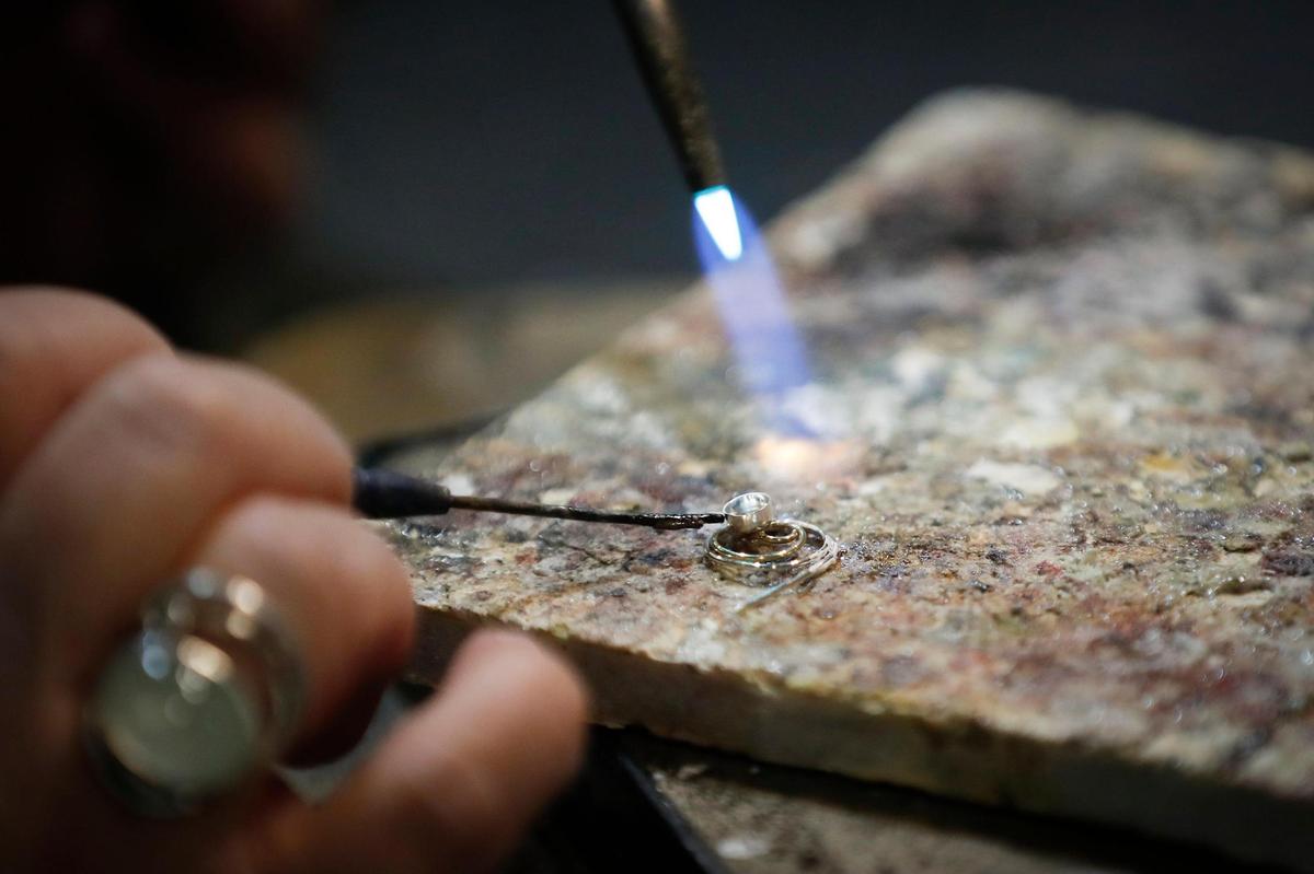 Rachel SavanŽ, of Lexington, Ky., owner and jewelry designer at SavanŽ Silver shows creates ÔcompassionÕ mask pin with an aventurine gemstone at SavanŽ Silver in Lexington, Thursday, Dec. 17, 2020.