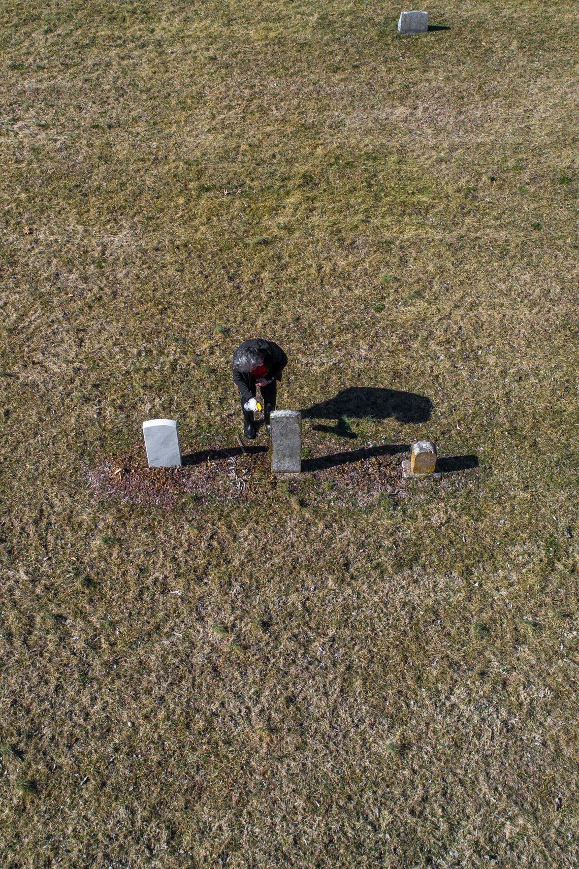 Yvonne Giles scrubs a headstones at African Cemetery No. 2 in Lexington, Ky., on Sunday, Feb. 20, 2022. Giles uses old military records to apply for headstones for veterans whose headstones have gone missing over the years.