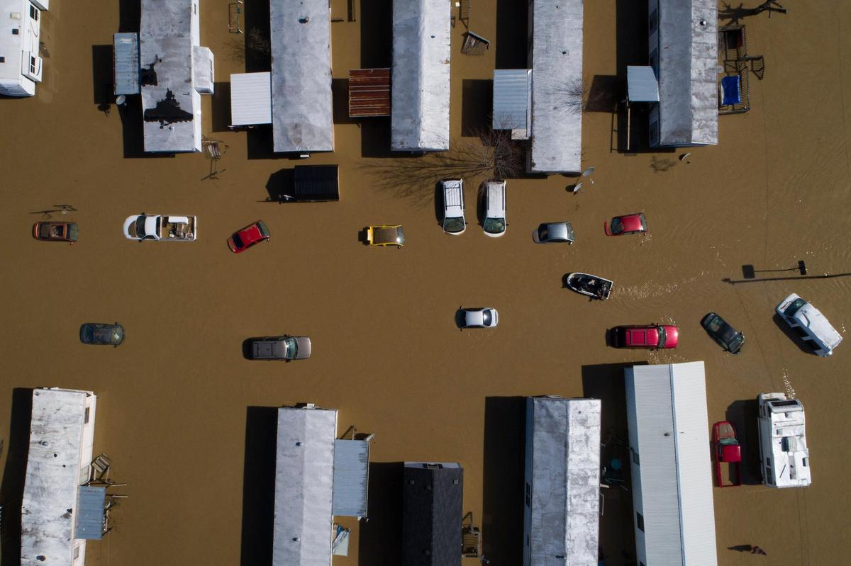 A boat weaves through partially submerged cars and trailer in city of Beattyville following heavy rains which caused the Kentucky River to flood, Tuesday, March 3, 2021.