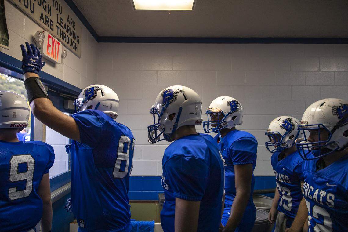 The Breathitt County Bobcats, including Bryce Hoskins, with hand up, a freshman tight end and linebacker, walk out of their locker room before taking the field for their game against South Laurel Friday, Aug. 30, 2019, in Jackson, Ky. The Bobcats won, 43-8.