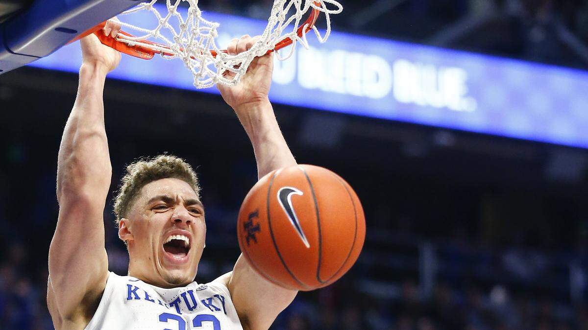 Kentucky’s Reid Travis (22) dunked over Kansas’ Dedric Lawson (1).