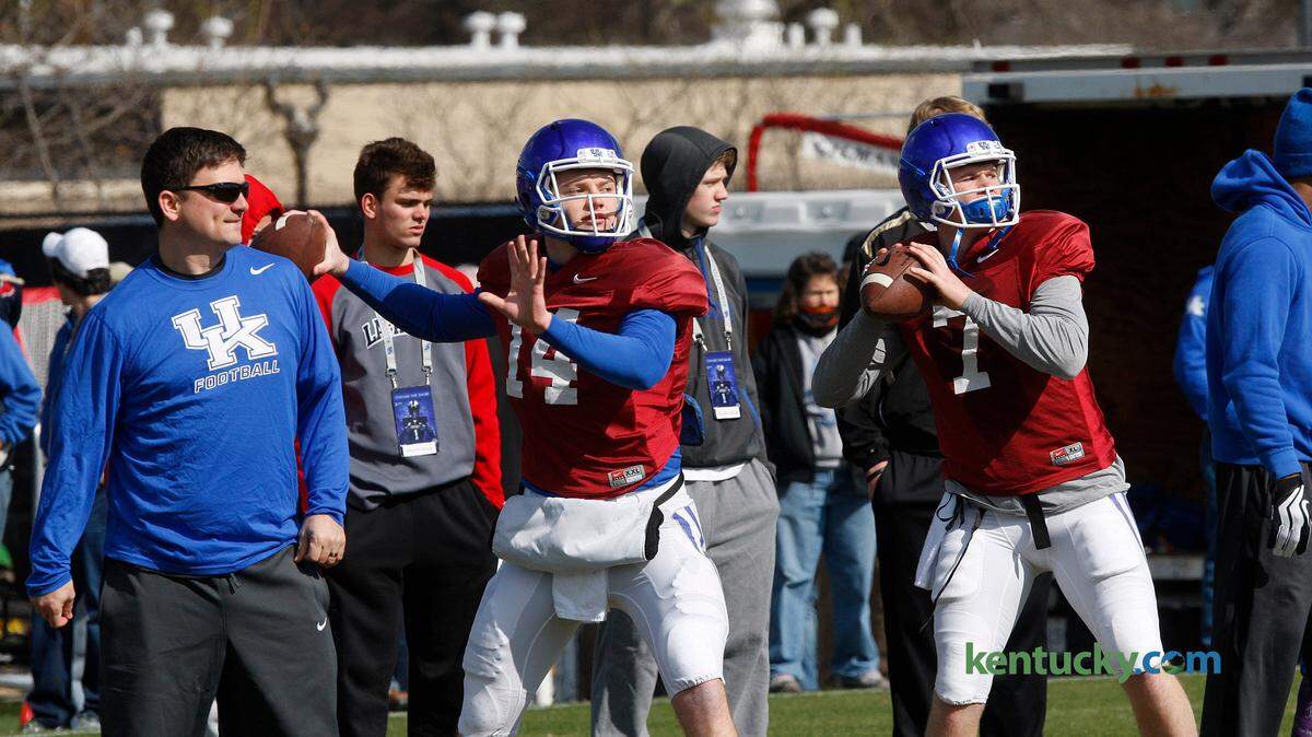 Offensive coordinator and quarterbacks coach Shannon Dawson, left, looks on as quarterbacks Patrick Towles and Drew Barker throw during drills at UK football practice on the Tim Couch Practice Fields at UK in Lexington, Ky., March 28, 2015. Photo by Matt Goins